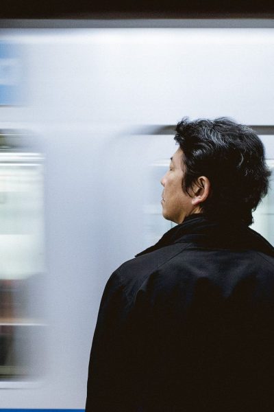 close-up photography of man standing front of train